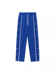 Royal blue vintage retro track pants with side buttons and white stripes in flat lay view