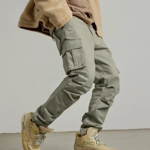 Détail du pantalon cargo vert olive avec grandes poches à rabat et tissu en sergé