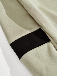 Macro shot of khaki knit fabric and black spliced tape detail with smooth stitching
