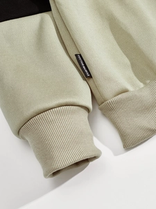 Close-up of ribbed cuffs and sage green fabric texture with black color blocking