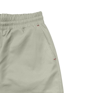 Détail de la taille élastique à cordon et poche latérale avec coutures rouges renforcées