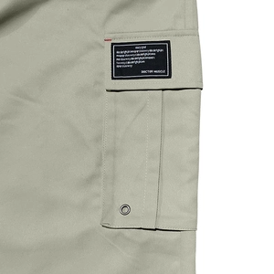 Gros plan détaillé sur la poche latérale du pantalon cargo avec étiquettes et surpiqûres