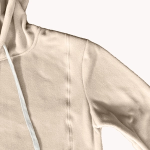 Detail of warm polar fleece hoodie texture with flatlock seams and beige drawstring cord