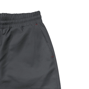 Détail de la taille élastique d'un pantalon cargo avec poches et coutures rouges contrastées