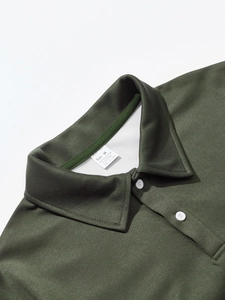 Detail view of the green polo shirt collar with white buttons and breathable mesh texture