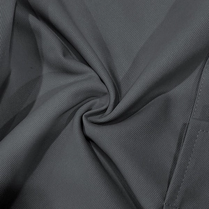Gros plan du tissu sergé gris foncé du pantalon cargo avec des coutures de poche nettes
