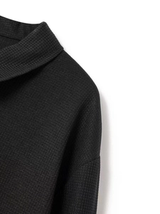 Gros plan sur la texture gaufrée noire et les détails de couture d'une veste pour homme