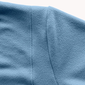 Macro detail of blue polar fleece fabric and reinforced stitching on a warm hoodie