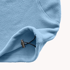 Close-up of light blue fleece hoodie hem with elastic drawstring and silver metal toggle