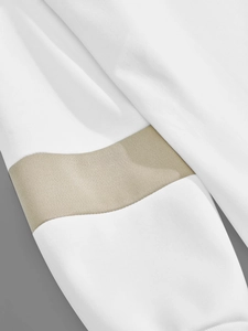 Detail of white knit sweatshirt sleeve with a khaki color-block contrast and texture