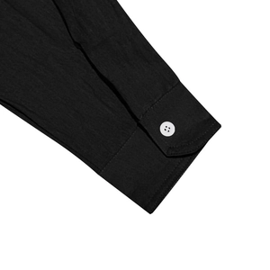 Close-up of black cotton linen shirt cuff with a white button and natural texture