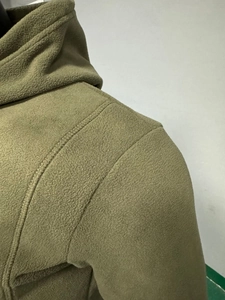 Macro shot of olive green polar fleece hoodie showing thick thermal texture and stitching