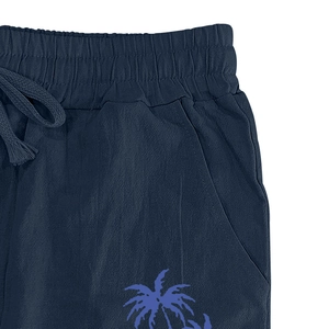 Detail of navy blue cotton linen pants with palm tree print and drawstring waistband