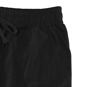 Detail der schwarzen Leinenhose für Herren mit elastischem Bund und Kordelzug mit Quasten