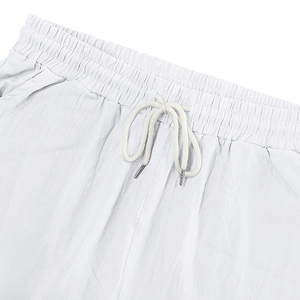 Détail de la taille élastique en lin blanc avec cordon de serrage et embouts argentés