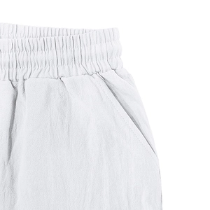 Détail du pantalon en lin blanc avec taille élastique et poches latérales pratiques