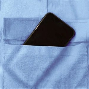 Détail d'une grande poche cargo sur un pantalon en lin contenant un grand smartphone