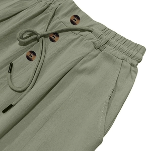 Dettaglio dei pantaloni in cotone e lino con coulisse elastica e bottoni tartarugati