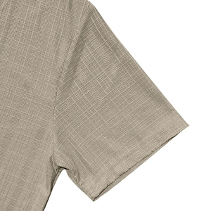Close-up of khaki linen-texture fabric with intricate jacquard weave and neat cuff stitching