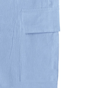 Detailed close-up of light blue linen cargo shorts featuring a functional square flap pocket