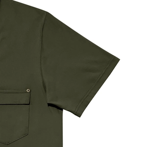 Dettaglio della maglietta verde oliva con tasca sul petto e rivetti in metallo bronzo