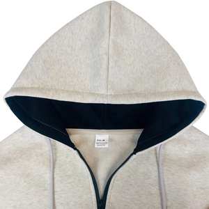 Detail view of grey zip-up hoodie featuring contrast black lining and size M material tag