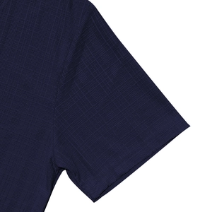 Close-up of navy blue short-sleeved shirt showing the knitted square texture and sleeve cuff