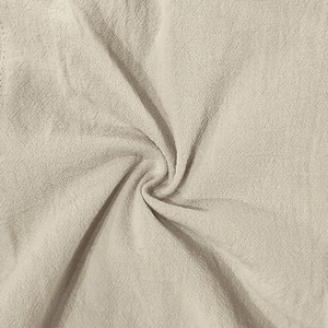 Close-up of natural beige linen fabric texture with soft folds and breathable weave