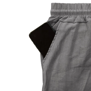 Détail du pantalon en lin gris avec taille élastique et grande poche latérale pour mobile