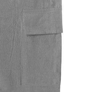 Détail de la texture du lin et de la poche à rabat sur le pantalon cargo gris