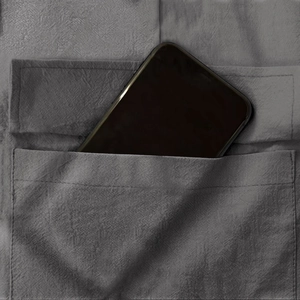 Détail du pantalon cargo montrant une poche profonde contenant un smartphone