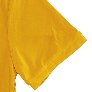 Close-up of bright yellow polo shirt sleeve with pique cotton texture and ribbed cuff