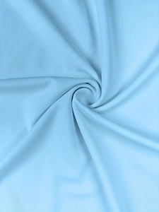 Macro shot of light blue ribbed knit fabric showing soft texture and vertical patterns