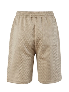 Primer plano detallado de los pantalones cortos beige para hombre con textura geométrica y cordón