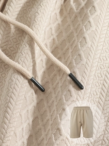 Primer plano de pantalones cortos de punto beige para hombre con textura de gofre y cordón