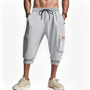 Detail of light gray cargo shorts with orange leather tag and elastic drawstring waist