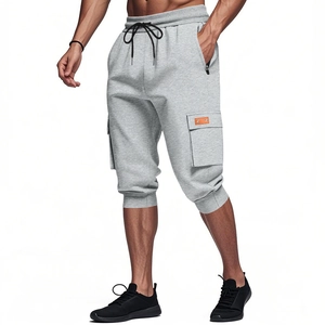 Detail of grey men's cargo shorts featuring large side pockets and orange leather badge