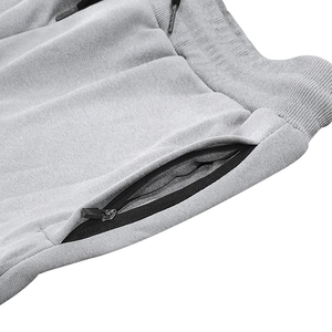 Detail of light gray tactical shorts with zipper pockets and adjustable drawstring waist