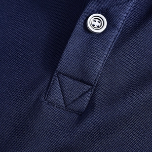 Macro shot of navy blue pique polo shirt placket with white button and X-stitch detail