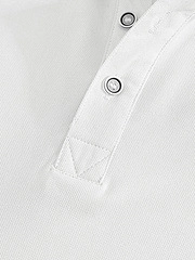 Close-up of white polo shirt showing pique cotton texture and two-button placket detail
