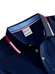 Detail of navy blue polo shirt collar featuring multi-color striped trim and size M label