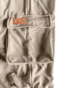 Detail of khaki cargo shorts pocket with leather patch and silver metal eyelets