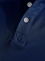 Macro shot of navy blue polo shirt collar with textured pique fabric and two buttons