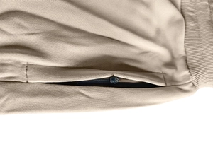 Detailed macro view of khaki cargo shorts featuring elastic waistband and metal zipper pocket