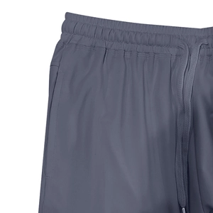 Detail view of dark grey athletic shorts featuring an elastic drawstring waistband and zip pocket
