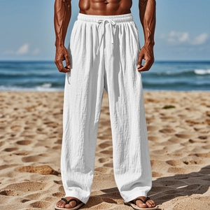 Linen drawstring trousers for men shown in a relaxed fit beach setting with white fabric