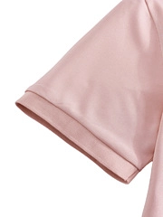 Close-up of pink polo shirt sleeve featuring reinforced folded hem and neat stitching