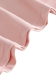 Detail of pink polo shirt showing double-stitched hem and textured breathable fabric