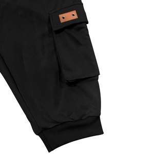 Detail view of heavy cargo shorts featuring a side pocket with leather patch and ribbed cuff