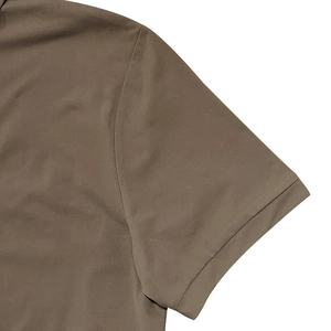 Close-up of brown casual polo shirt showing cotton fabric texture and sleeve stitching details